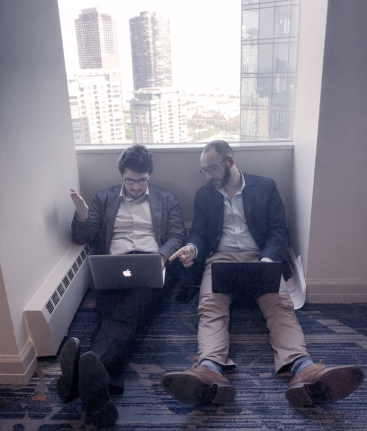 George Vavaroutsos consulting with someone on the computer.