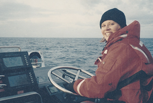 Heather Doucette driving a boat on the lake.