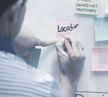 Man writing on a post-it note.